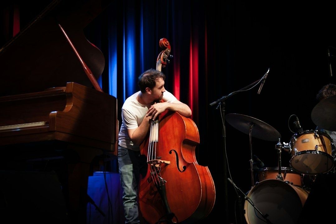 Jazzmusiker lutar sig mot en kontrabas på en scen
